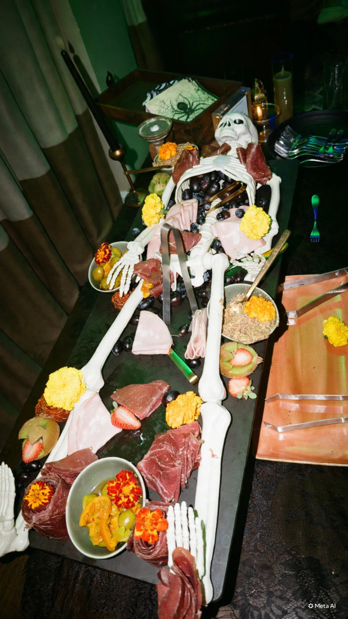 A decorative skeleton surrounded by sliced meats, fruit and flowers at Estancia's Halloween party.