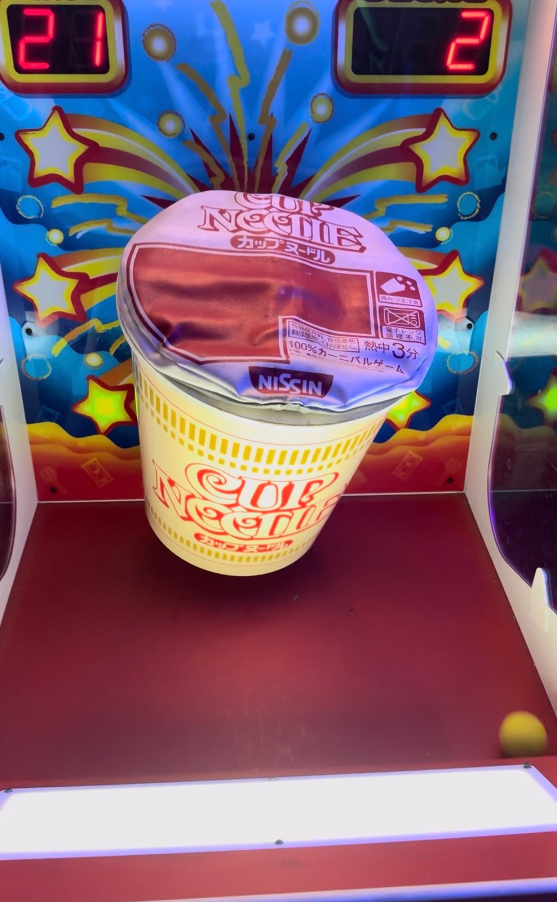 Cup Noodle-themed arcade game with a large noodle-cup target and digital score displays.