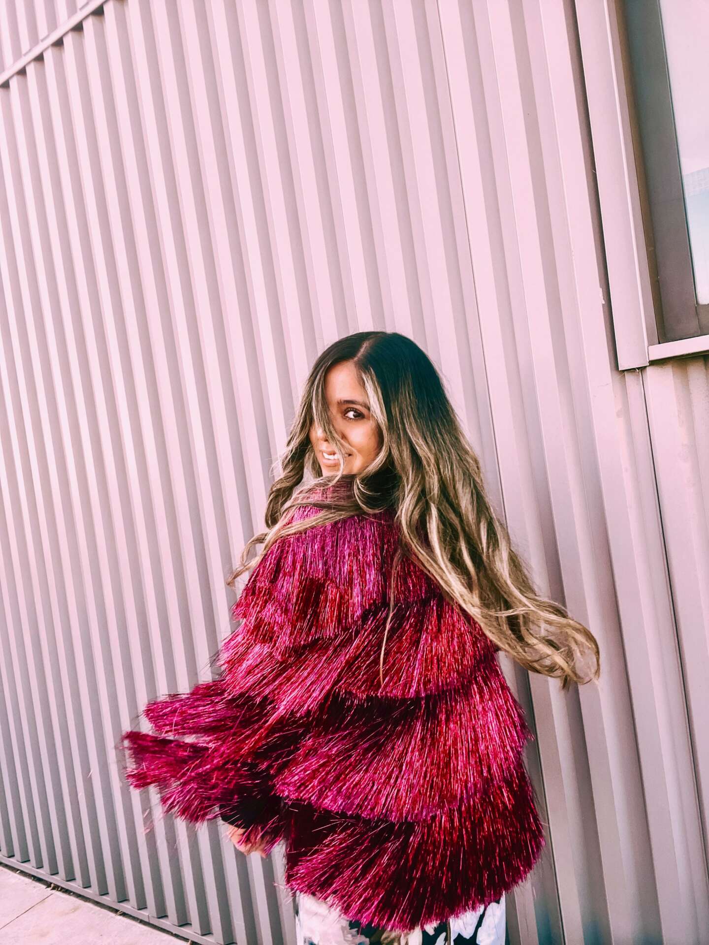Giselle Lelux wearing a pink fringe jacket