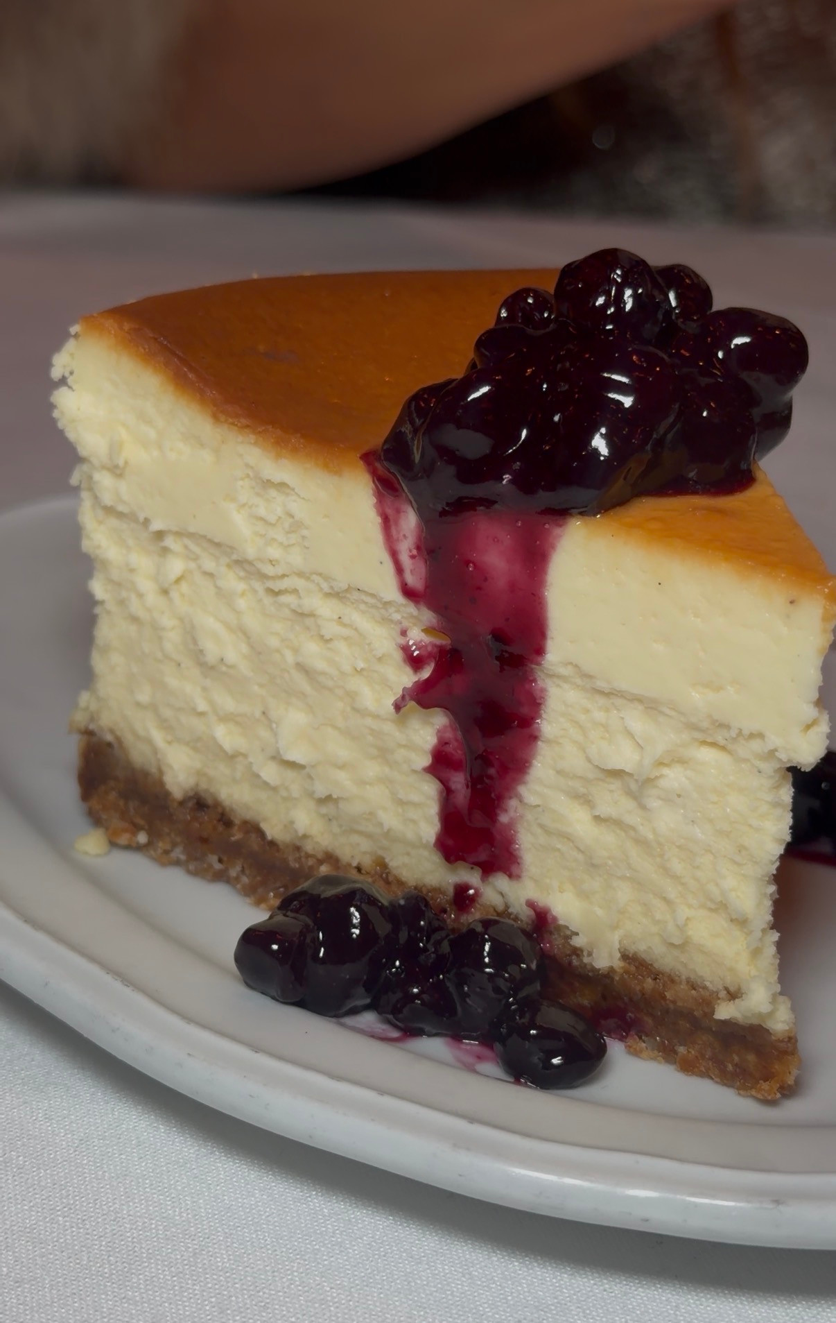 A slice of cheesecake topped with dark berries at Rustic Root.