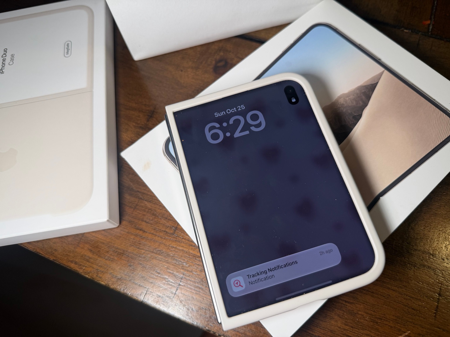 Closed iPhone Duo in a pale case resting on its product box beside separate case packaging.
