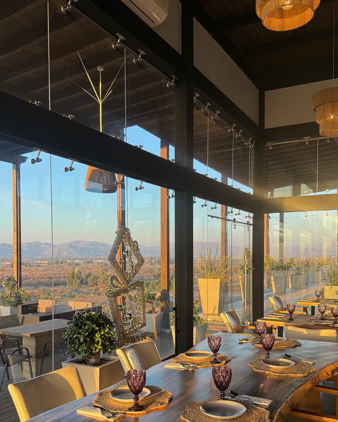 Set dining tables beside large windows looking out over the valley at Montevalle.