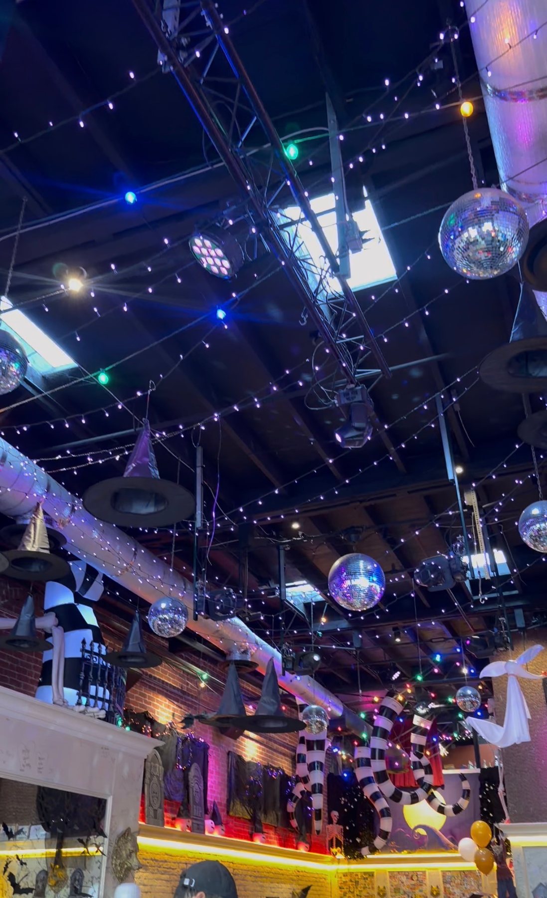 Hanging witch hats, disco balls and string lights above Werewolf's Halloween-decorated interior.