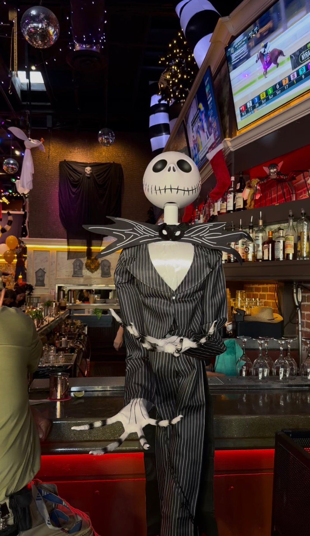 A Jack Skellington figure in a pinstripe suit beside the bar at Werewolf.